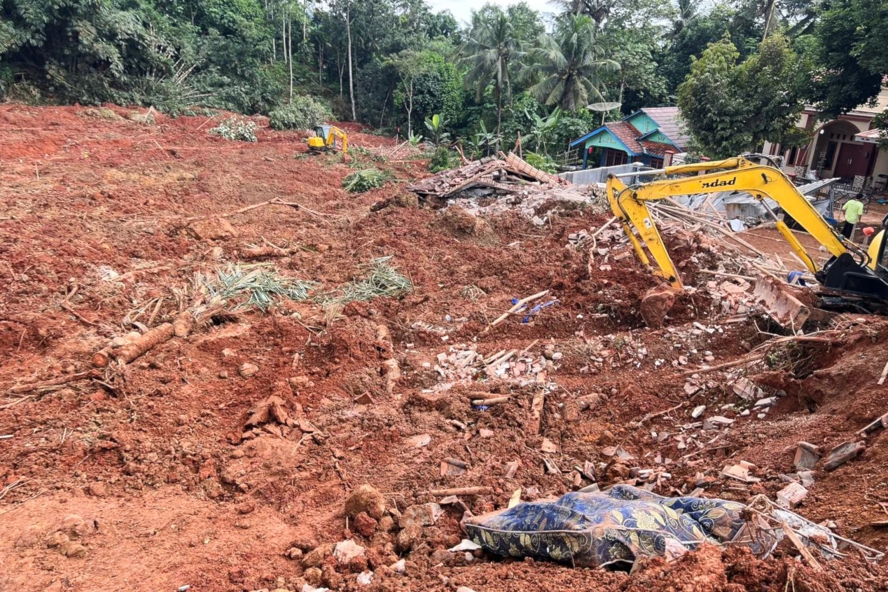 Rescuers use a heavy machine during the search for victims of a landslide in Cilacap, Ion Java island, Indonesia, on November 14, 2025. (AP Photo/Agus Fitrah)