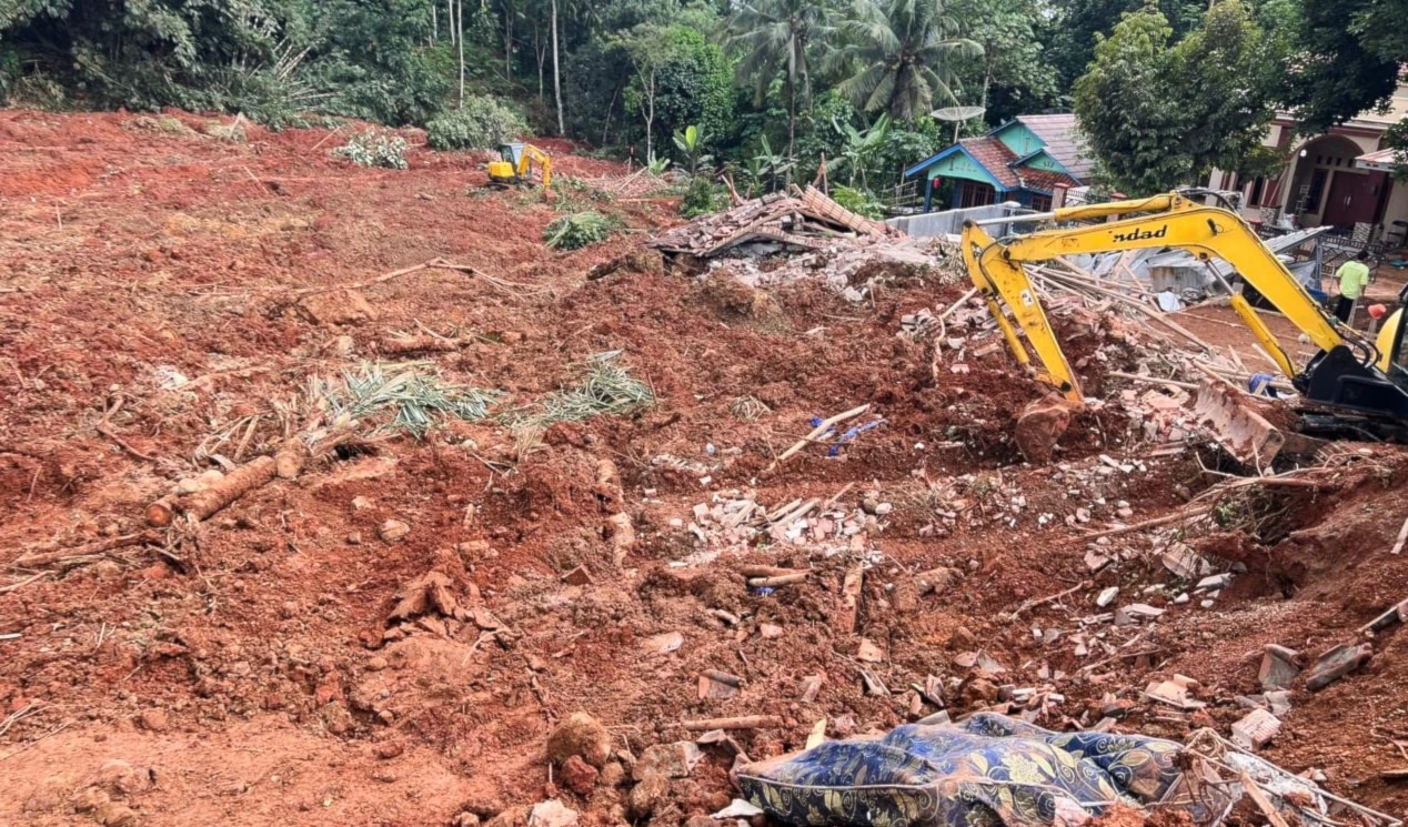 Rescuers use a heavy machine during the search for victims of a landslide in Cilacap, Ion Java island, Indonesia, on November 14, 2025. (AP Photo/Agus Fitrah)