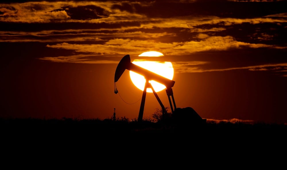 The sun sets behind an idle pump jack near Karnes City, USA, on April 8, 2020. (AP)