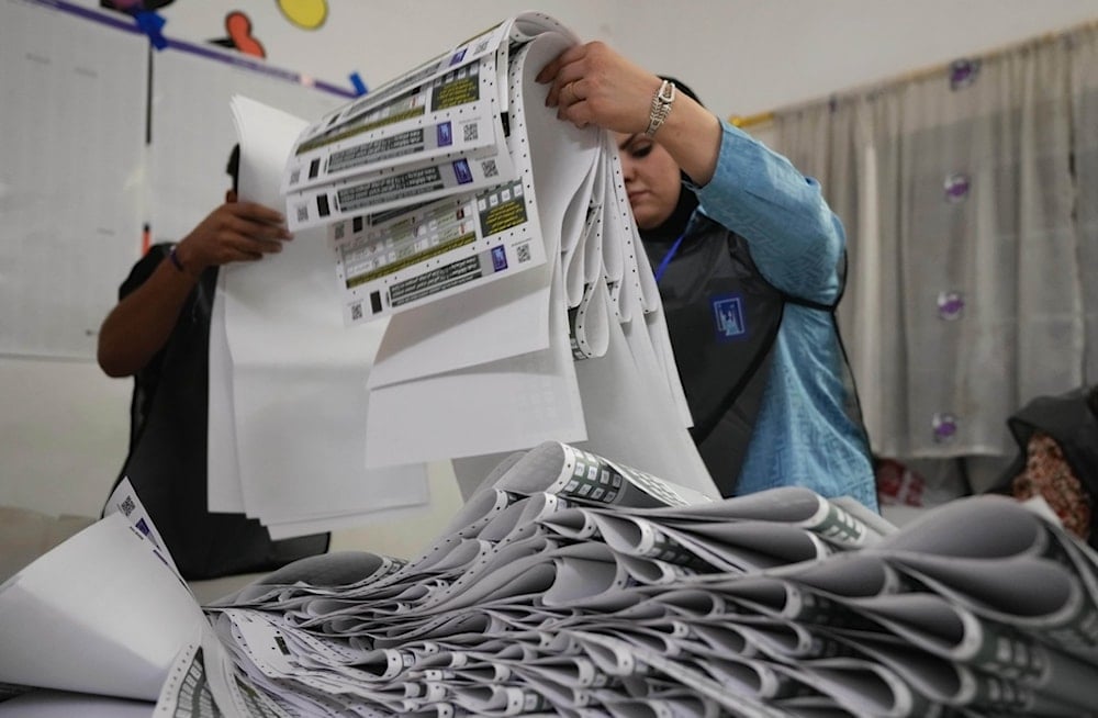 Election workers gather parliamentary election ballots after the polls closed in Baghdad, Iraq, Novomber 11, 2025 (AP)