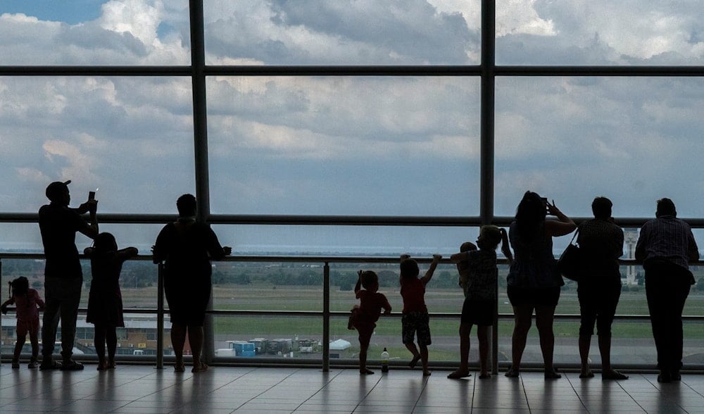 Families watch planes on the tarmac at Johannesburg's OR Tambo's airport, Monday Nov. 29, 2021. (AP)