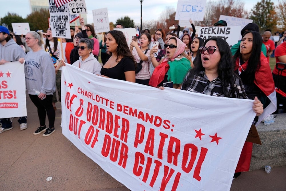 People protest against federal immigration enforcement Saturday, November 15, 2025, in Charlotte, N.C. (AP Photo/Erik Verduzco)