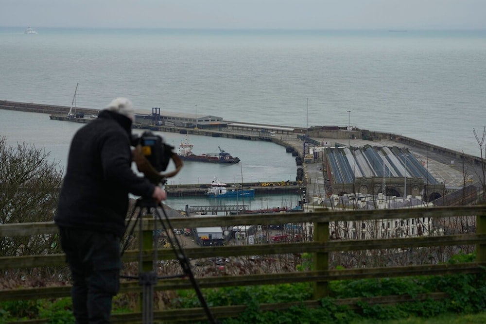 A cameraman films the migrant processing centre in Dover, Kent, England, Tuesday, March 7, 2023. (AP)