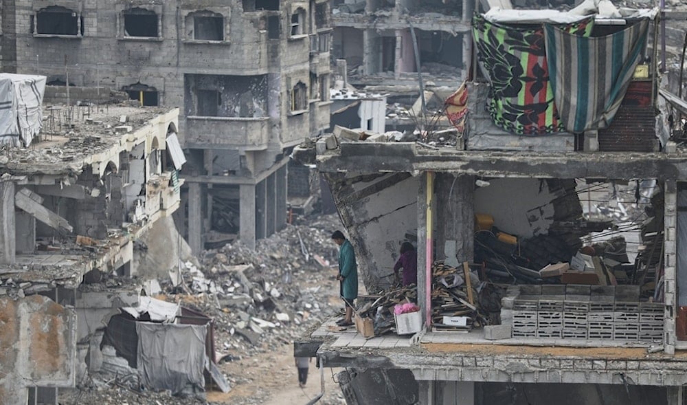 A man and a woman stand in their damaged apartment, surrounded by the the rubble of neighboring residences, all devastated by Israeli bombardments, in Gaza City, Friday Nov.14, 2025. (AP)
