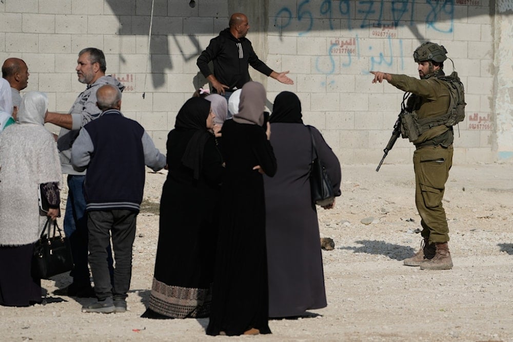 An Israeli soldier disperses people taking part in a protest calling for the return of displaced Palestinians to their houses in the Nur Shams refugee camp in the West Bank city of Tulkarem on Tuesday, November 18, 2025 (AP)