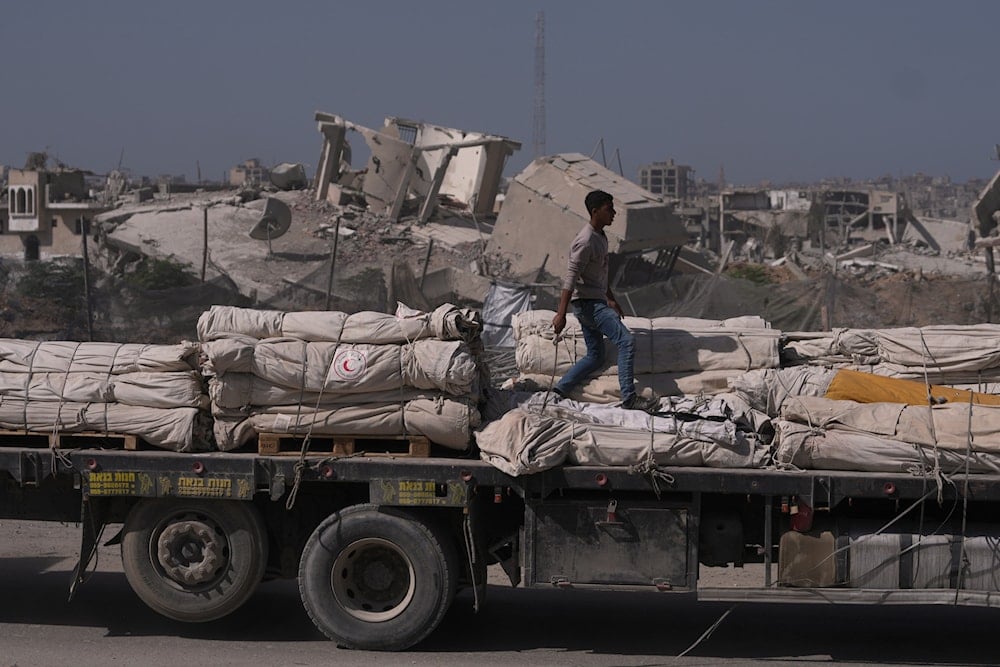 A truck carrying humanitarian aid drives through Khan Younis, in the southern Gaza Strip, Monday, Oct. 20, 2025 (AP)
