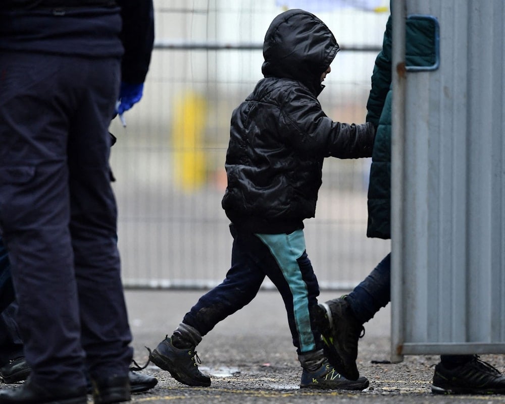 Border Force officers assisting a child, United Kingdom, undated (AFP)