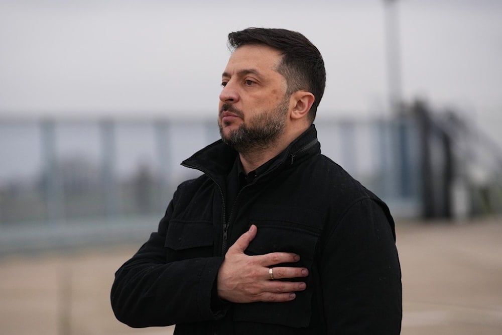 Ukrainian President Volodymyr Zelenskyy listens to his national anthem as he arrives at the Villacoublay air base near Paris, Monday, November 17, 2025 (AP)