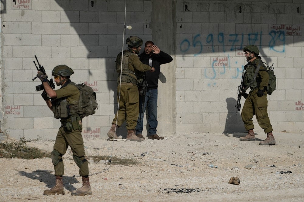 Israeli soldiers detain a man during a protest calling for the return of displaced Palestinians to their houses in the Nur Shams refugee camp in the West Bank city of Tulkarem on Tuesday, Nov. 18, 2025 (AP)