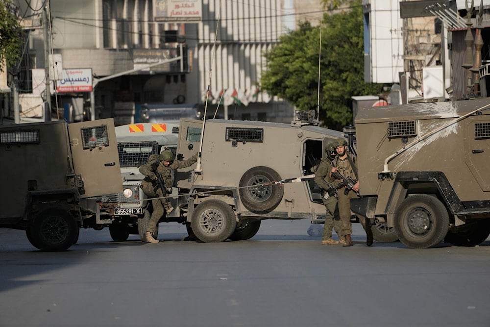 Israeli soldiers tow one of their vehicles during a military raid in the Palestinian West Bank city of Nablus, Thursday, Nov. 20, 2025 (AP)