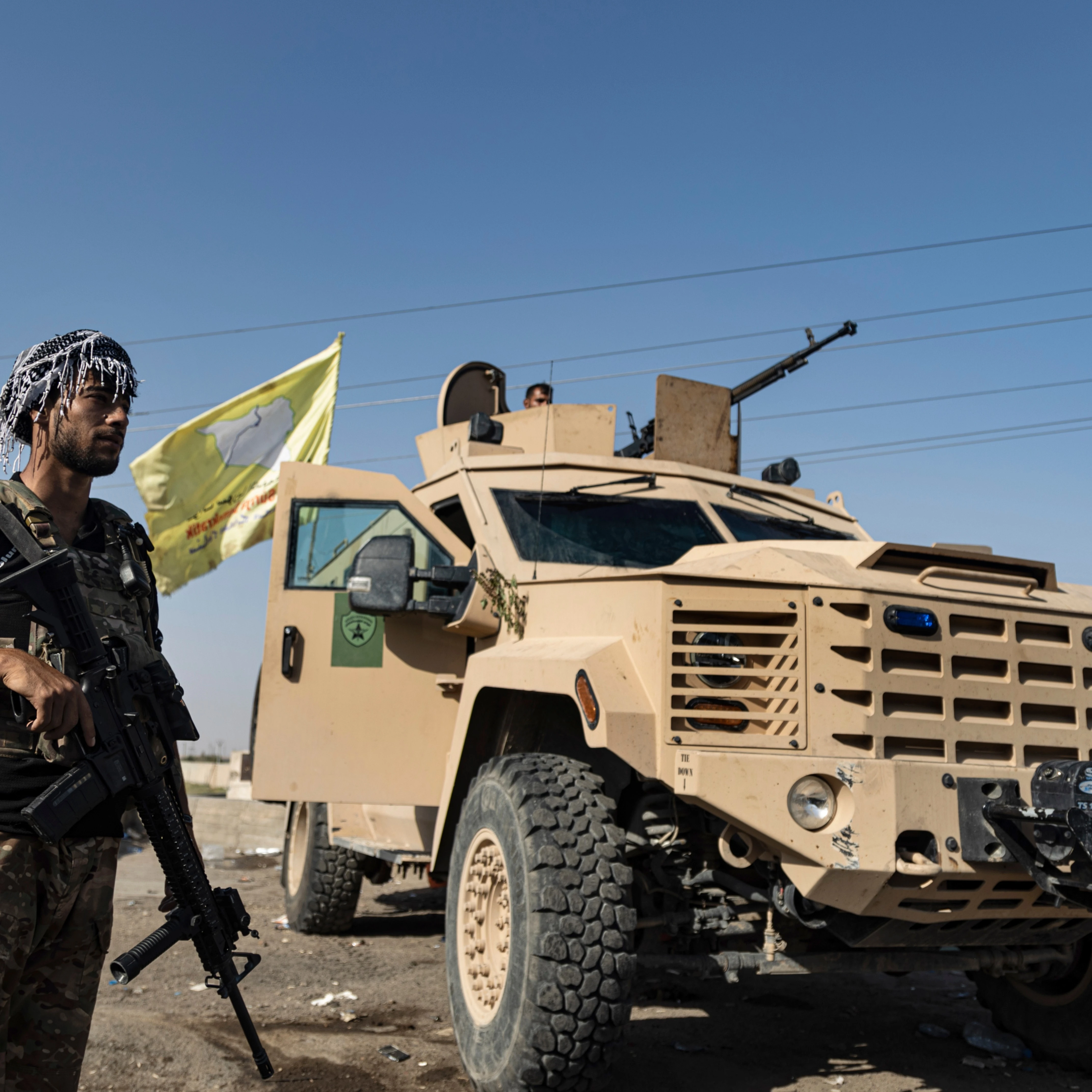 A US-backed Syrian Democratic Forces (SDF) fighter stands next an armored vehicle, at al-Sabha town in the eastern countryside of Deir Ezzor, Syria, Monday, Sept. 4, 2023 (AP)
