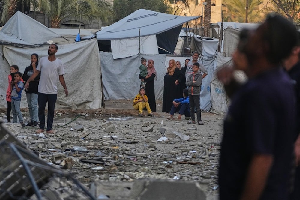 Palestinians inspect the damage to a house targeted by an Israeli strike in Deir al-Balah, in the central Gaza Strip, Saturday, November 22, 2025. (AP Photo/Abdel Kareem Hana)