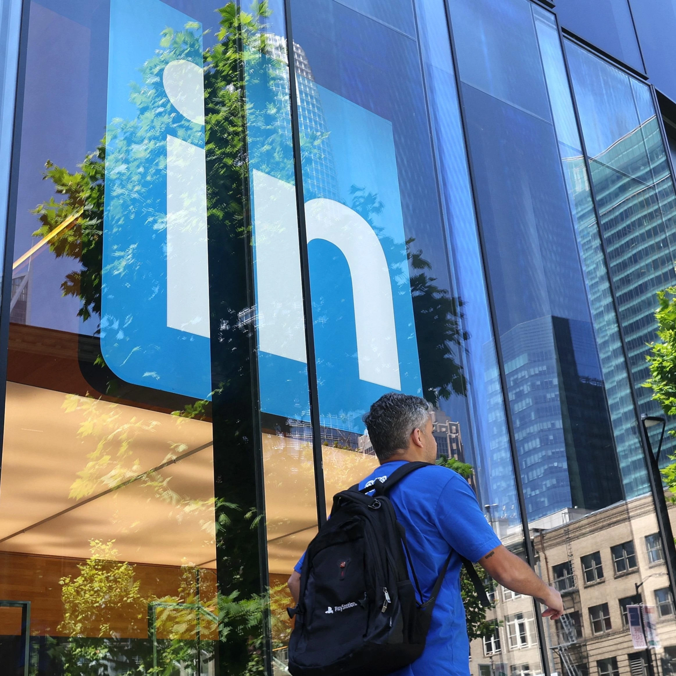 A pedestrian walks by a sign at a LinkedIn office on July 26, 2023 in San Francisco, California. (AFP)