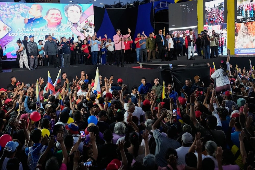 Venezuelan President Nicolas Maduro takes the oath to people joining a state-organized civilian defense network in the Petare neighborhood of Caracas, Venezuela, Saturday, November 15, 2025. (AP Photo/Ariana Cubillos)