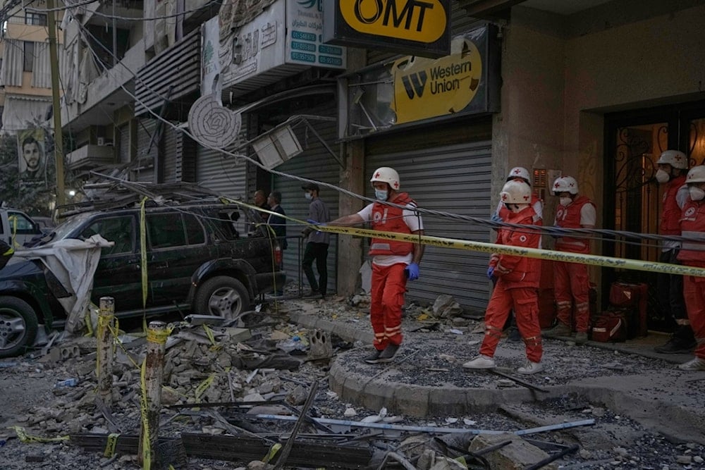 Lebanese Red Cross volunteers work at the site where an apartment building was hit during an Israeli airstrike on Dahiyeh in the southern suburb of Beirut, Sunday November 23, 2025. (AP Photo/Bilal Hussein)