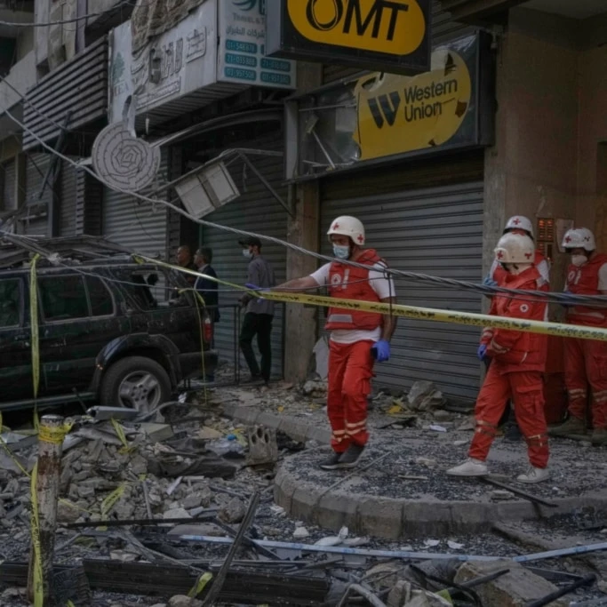 Lebanese Red Cross volunteers work at the site where an apartment building was hit during an Israeli airstrike on Dahiyeh in the southern suburb of Beirut, Sunday November 23, 2025. (AP Photo/Bilal Hussein)