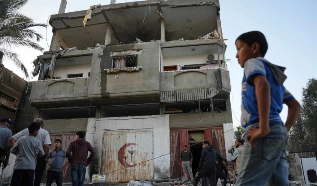 Palestinians inspect the damage to a house targeted by an Israeli strike in Deir al-Balah, in the central Gaza Strip, Saturday, November 22, 2025 (AP)