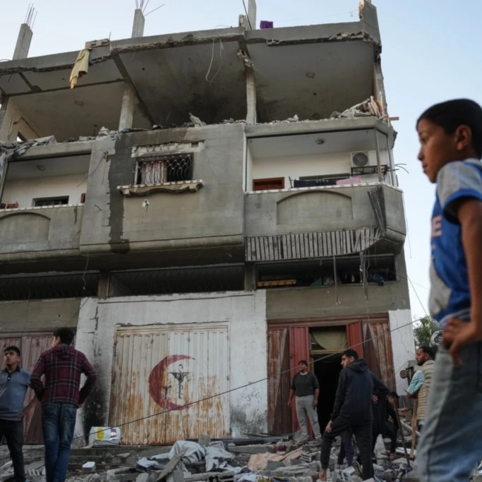 Palestinians inspect the damage to a house targeted by an Israeli strike in Deir al-Balah, in the central Gaza Strip, Saturday, November 22, 2025 (AP)