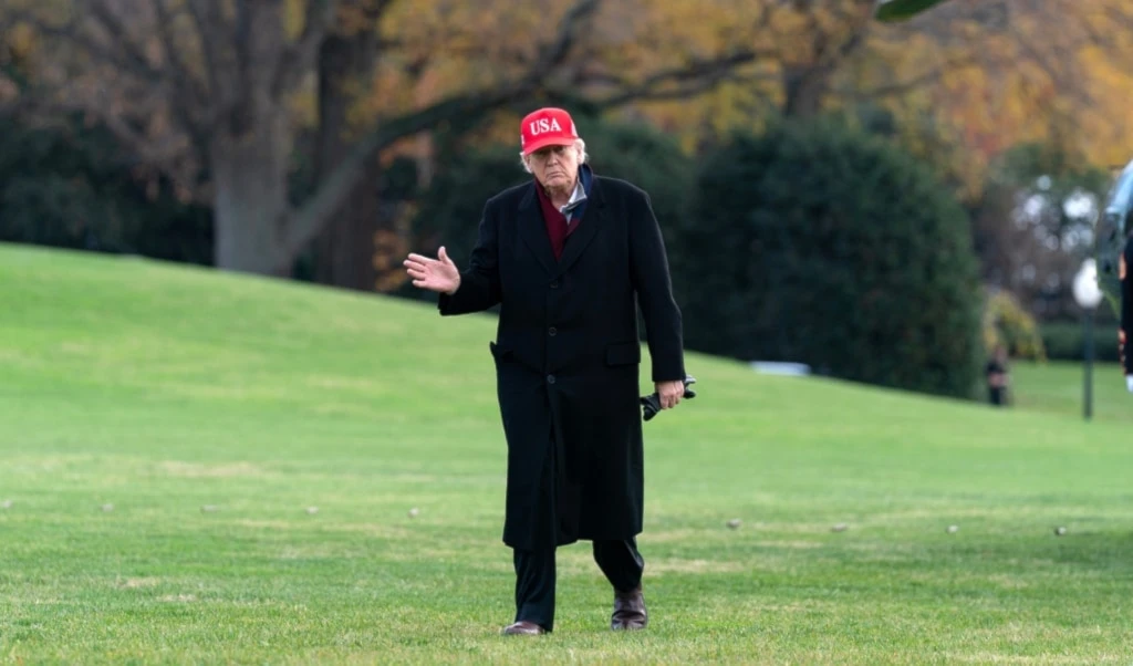 US President Donald Trump waves to the media as he walks in the South Lawn upon his arrival to the White House, Saturday, November 22, 2025, in Washington. (AP Photo/Jose Luis Magana)