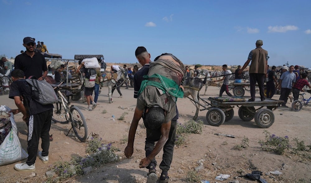A Palestinian carries the body of a man killed while trying to receive aid near a distribution center operated by the U.S.-backed Gaza Humanitarian Foundation (GHF) in Netzarim, in the Gaza Strip, Aug. 4, 2025. (AP)