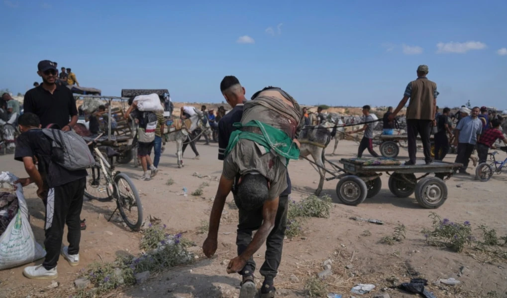 A Palestinian carries the body of a man killed while trying to receive aid near a distribution center operated by the U.S.-backed Gaza Humanitarian Foundation (GHF) in Netzarim, in the Gaza Strip, Aug. 4, 2025. (AP)