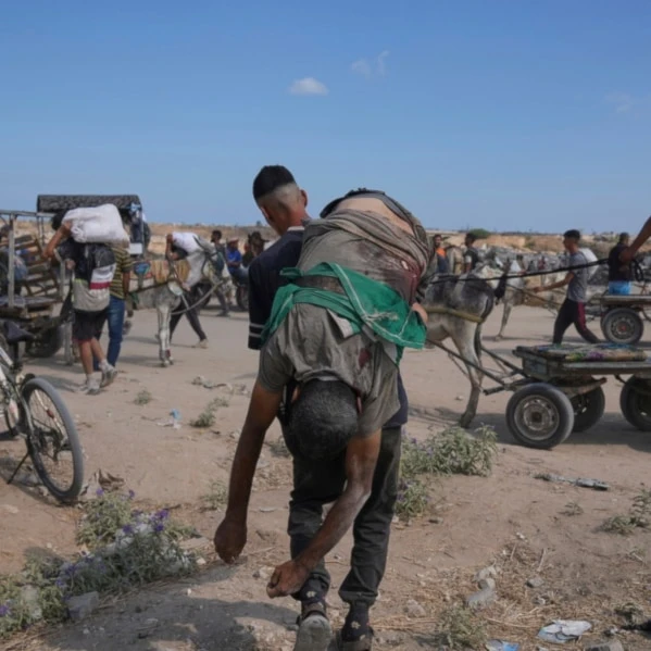 A Palestinian carries the body of a man killed while trying to receive aid near a distribution center operated by the U.S.-backed Gaza Humanitarian Foundation (GHF) in Netzarim, in the Gaza Strip, Aug. 4, 2025. (AP)