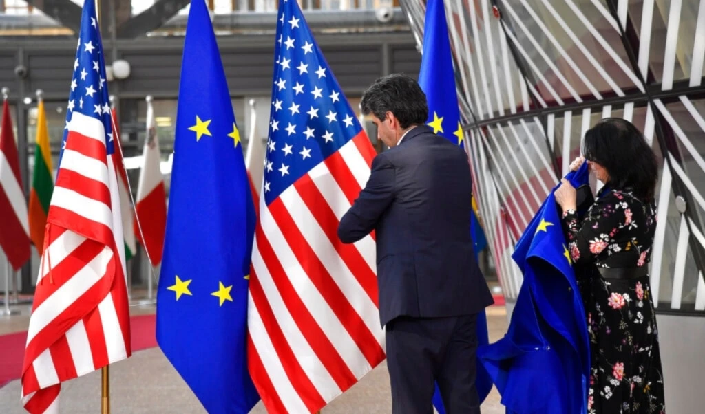 A member of protocol puts up the European Union and U.S. flags for an EU summit in Brussels, Thursday, March 24, 2022. (AP)