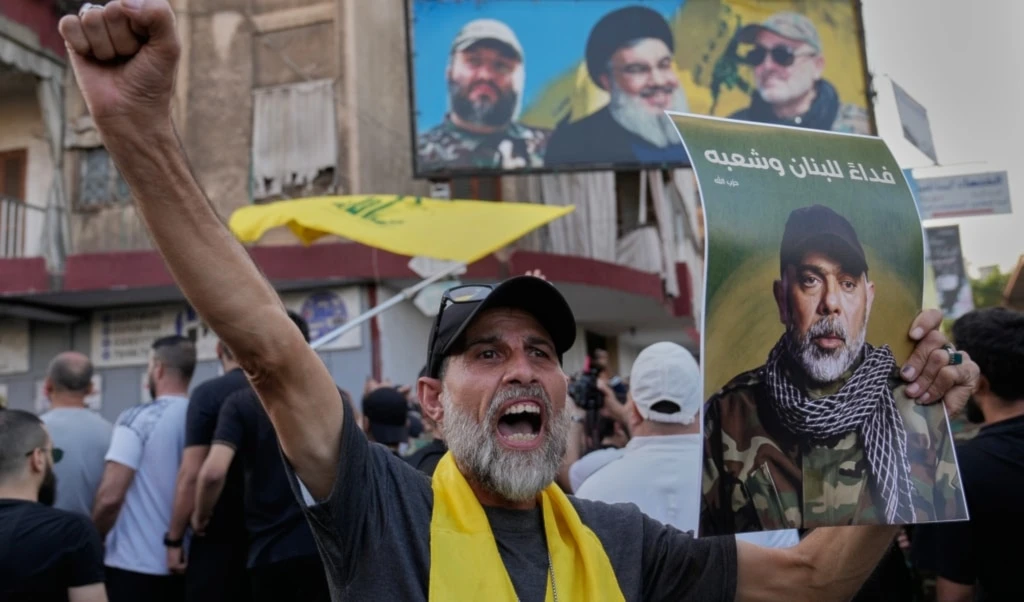A Lebanese citizen shouts slogans as he carries a portrait of Hezbollah's Chief of Staff Haitham Tabtabai during his funeral procession in the southern suburb of Beirut, Lebanon, Nov. 24, 2025. (AP)