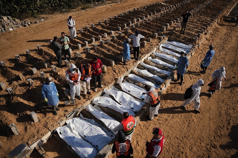 Bodies of unidentified Palestinians returned from the occupied Palestinian territories as part of the ceasefire deal are buried in Deir al-Balah, Gaza Strip, Sunday, November 23, 2025 (AP)