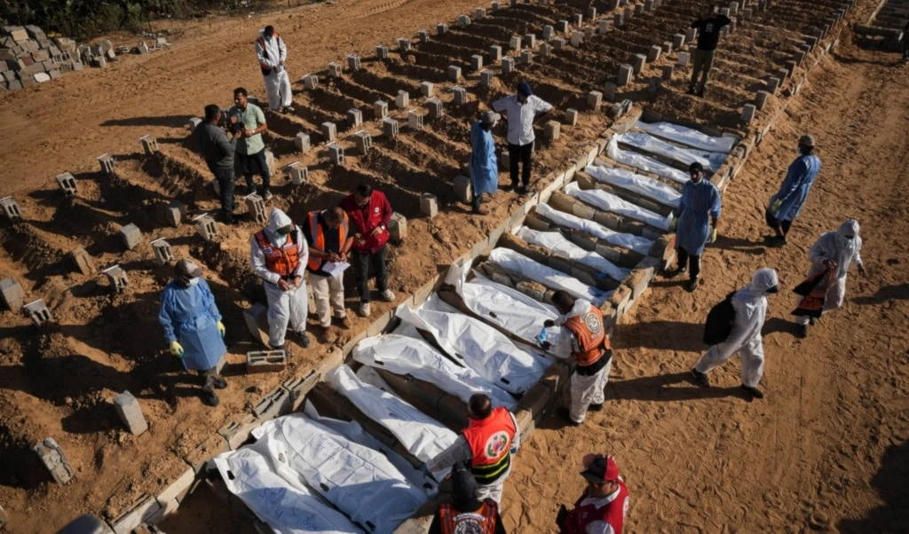 Bodies of unidentified Palestinians returned from the occupied Palestinian territories as part of the ceasefire deal are buried in Deir al-Balah, Gaza Strip, Sunday, November 23, 2025 (AP)