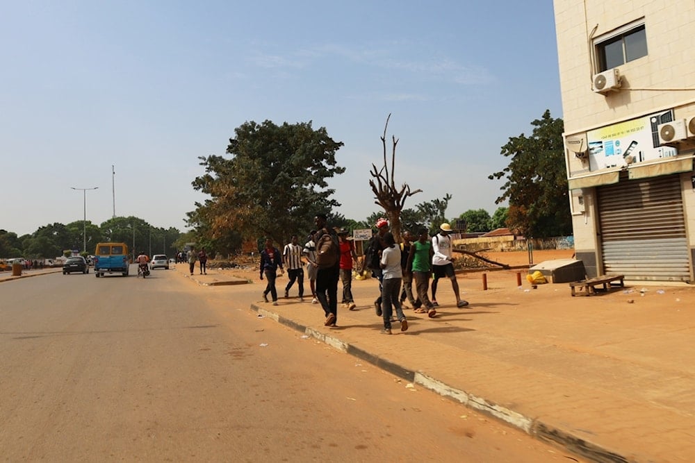 People walk on the street in Bissau, Guinea-Bissau, Wednesday, Nov. 26, 2025. (AP Photo/Darcicio Barbosa)