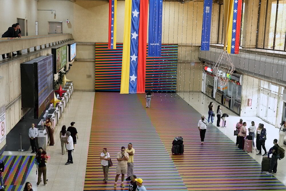 Travelers wait in the main hall of the Simon Bolivar Maiquetia International Airport in Maiquetia, Venezuela, Sunday, November 23, 2025 (AP Photo/Ariana Cubillos)