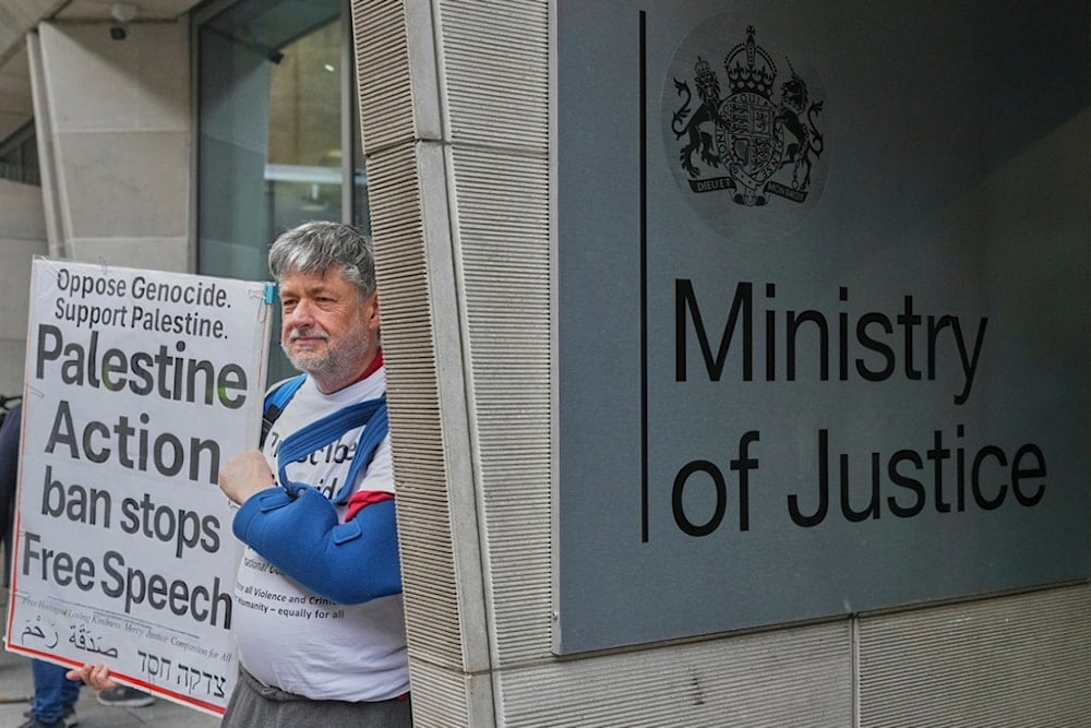 Protesters hold placards outside the Ministry of Justice during a Palestine Action demonstration in London, Thursday, November 20, 2025. (AP Photo/Frank Augstein)
