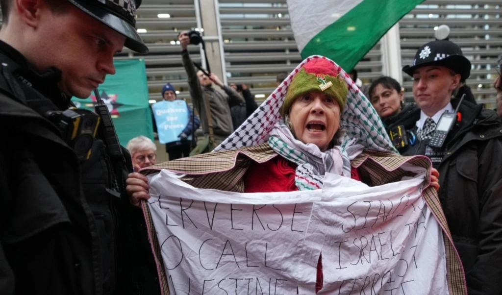 Police officers detain a protester outside the Home Office during a Palestine Action demonstration in London, Monday, November 24, 2025. (AP Photo/Kirsty Wigglesworth)