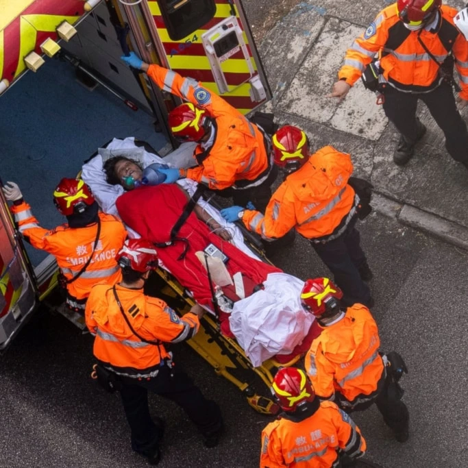 Health workers evacuate a woman from a fire which broke out at Wang Fuk Court, a residential estate in the Tai Po district of Hong Kong's New Territories, Thursday, November 27, 2025. (AP Photo/Chan Long Hei)
