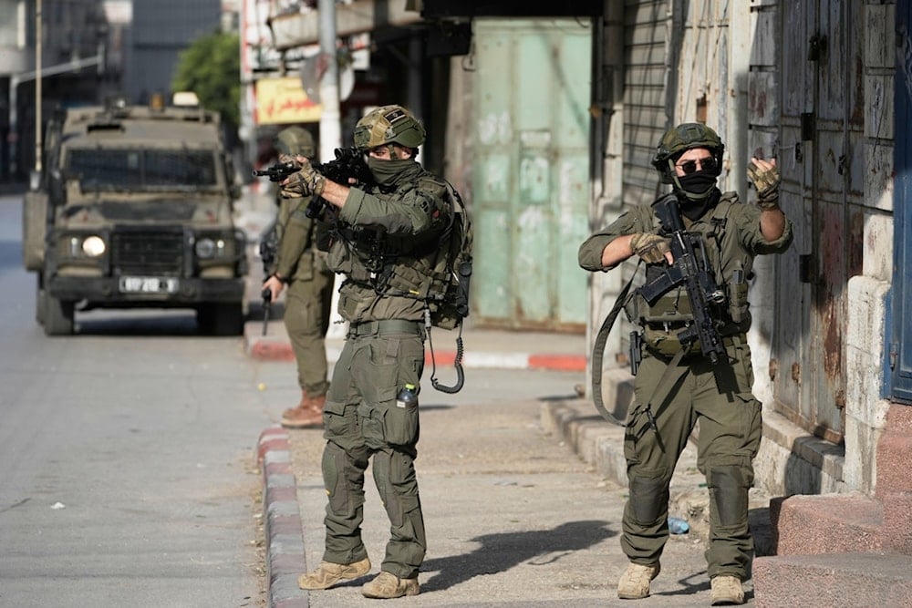 Israeli soldiers aim their weapons during a military raid in the Palestinian West Bank city of Nablus, Thursday, November 20, 2025. (AP Photo/Majdi Mohammad)