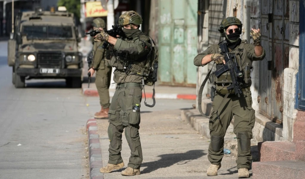 Israeli soldiers aim their weapons during a military raid in the Palestinian West Bank city of Nablus, Thursday, November 20, 2025. (AP Photo/Majdi Mohammad)