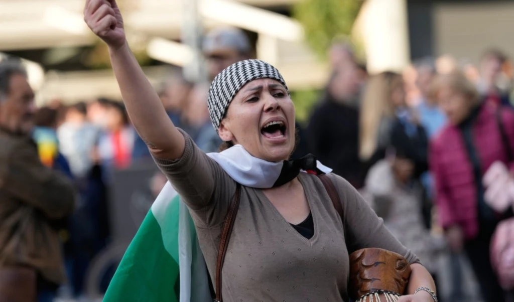 A woman protests against the participation of the Israeli national team in the 2026 Soccer World Cup qualification match against Italy being played in the evening in Udine, Italy, Oct. 14, 2025. (AP Photo/Luca Bruno)