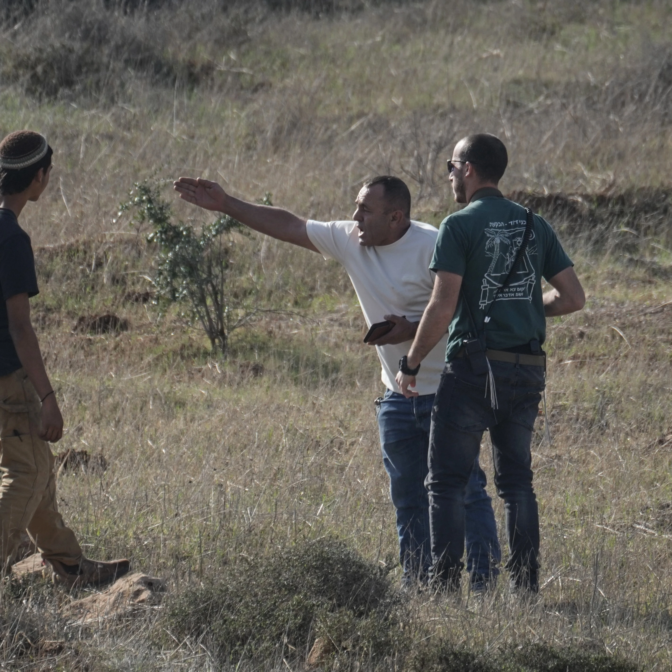 A Palestinian resident of the West Bank village of Tarkumiya argues with Israeli settlers during a protest against what Palestinians say is a land confiscation in the area, Friday, Nov. 28, 2025 (AP)