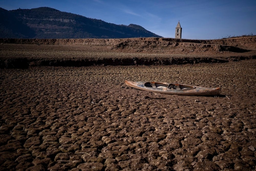 An abandoned canoe sits on the cracked ground amid a drought at the Sau reservoir, north of Barcelona, Spain, Monday, Jan. 22, 2024 (AP)