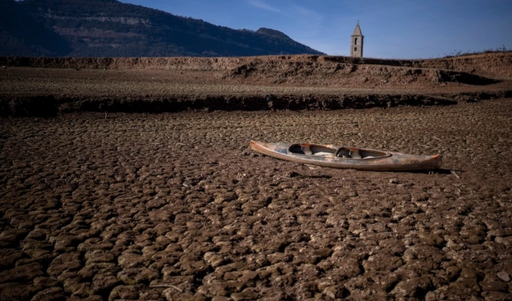 An abandoned canoe sits on the cracked ground amid a drought at the Sau reservoir, north of Barcelona, Spain, Monday, Jan. 22, 2024 (AP)