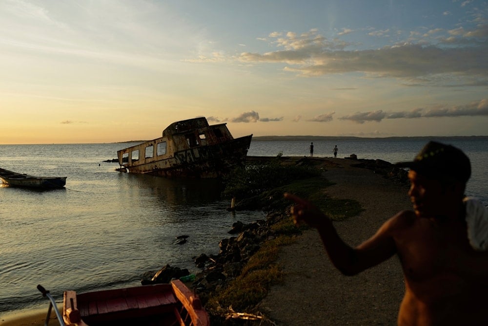 A boat sits stranded along the shore in Cumana, capital of Venezuela's Sucre state, Friday, Sept. 12, 2025. (AP Photo/Ariana Cubillos)
