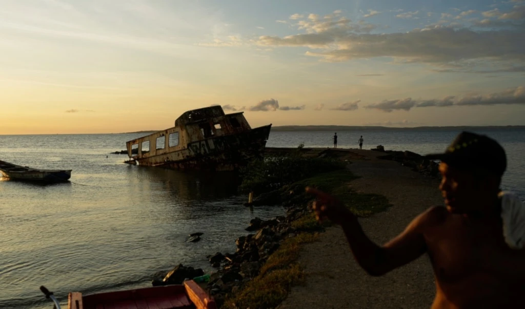 A boat sits stranded along the shore in Cumana, capital of Venezuela's Sucre state, Friday, Sept. 12, 2025. (AP Photo/Ariana Cubillos)