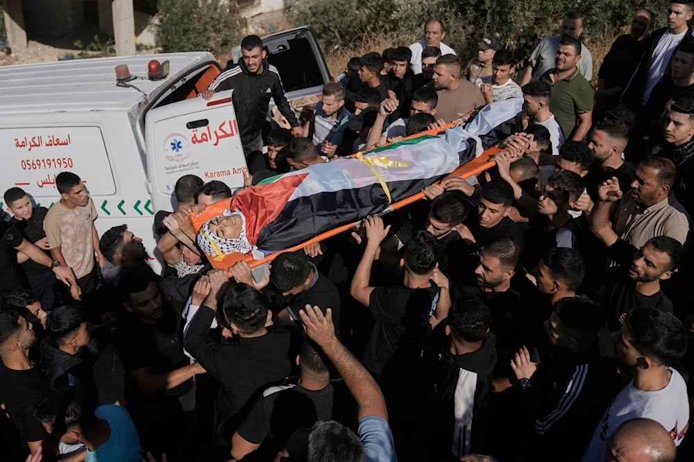 Mourners carry the body of Palestinian Jamil Hanani, 17, who was killed after being shot in the chest in an Israeli raid, according to health authorities, during his funeral in the West Bank village of Beit Furik, Monday, Nov. 3, 2025 (AP)