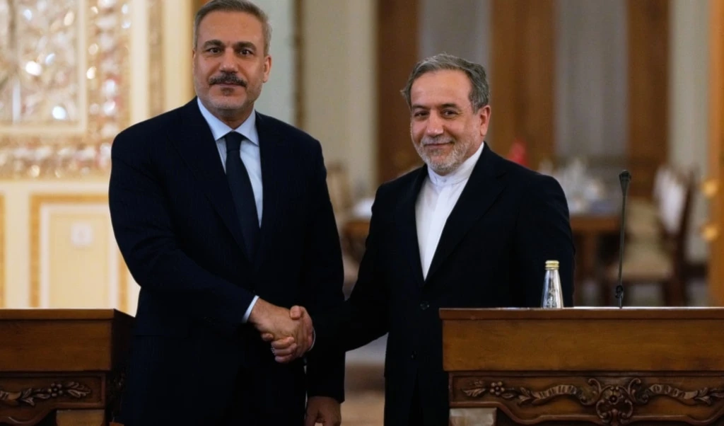 Iranian Foreign Minister Abbas Araghchi, right, and his Turkish counterpart Hakan Fidan shake hands at the conclusion of their joint news briefing after their meeting in Tehran, Iran, Sunday, November 30, 2025 (AP)