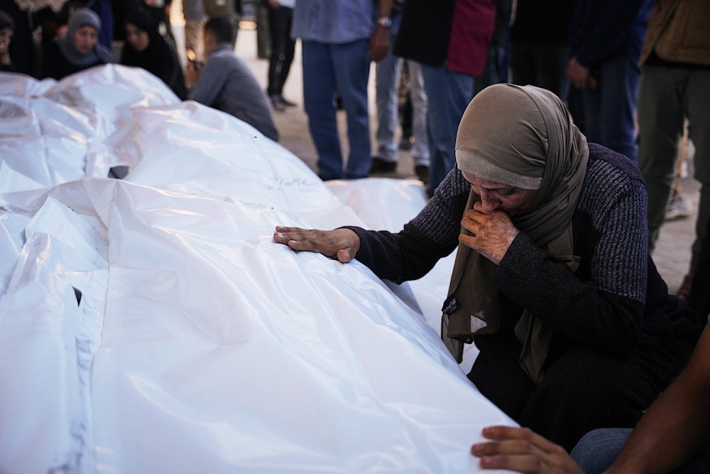 Ahmed Al-Bohisi mourns over the body of his cousin, Mohammad Abu Shawish, 18, who was killed in an Israeli military strike, during his funeral at Al-Aqsa Hospital in Deir al-Balah in the Gaza Strip, on November 23, 2025. (AP Photo/Abdel Kareem Hana)