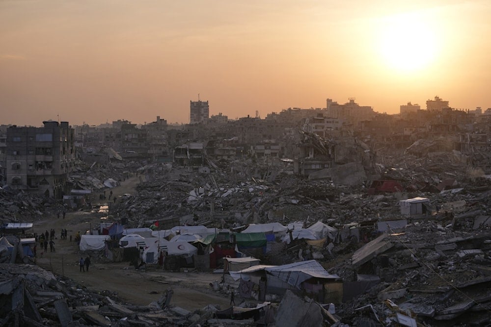 Tents sheltering displaced Palestinians stand amid the destruction left by the Israeli air and ground offensive in Gaza City, Friday, November 28, 2025 (AP)