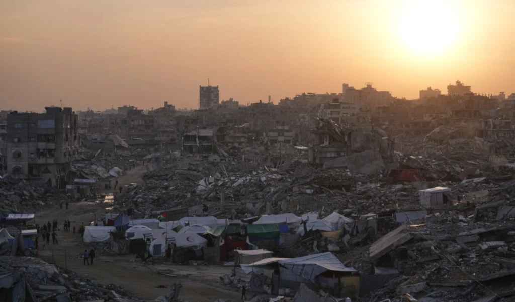 Tents sheltering displaced Palestinians stand amid the destruction left by the Israeli air and ground offensive in Gaza City, Friday, November 28, 2025 (AP)