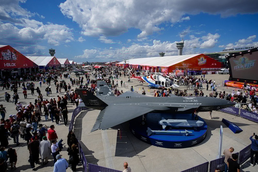 People watch an unmanned combat aircraft Bayraktar Kizilelma displayed during Teknofest fair at Ataturk airport, in Istanbul, Turkey, on September 18, 2025. (AP Photo/Emrah Gurel)