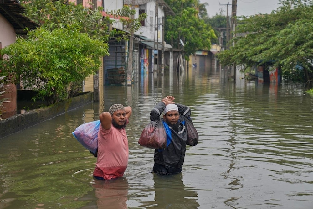 Flood victims wade through water in Colombo, Sri Lanka, Saturday, Nov, 29, 2025. (AP Photo/Eranga Jayawardena)